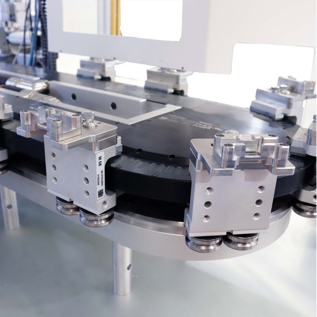 Magnetic conveyor moving multiple custom nests in automated assembly system