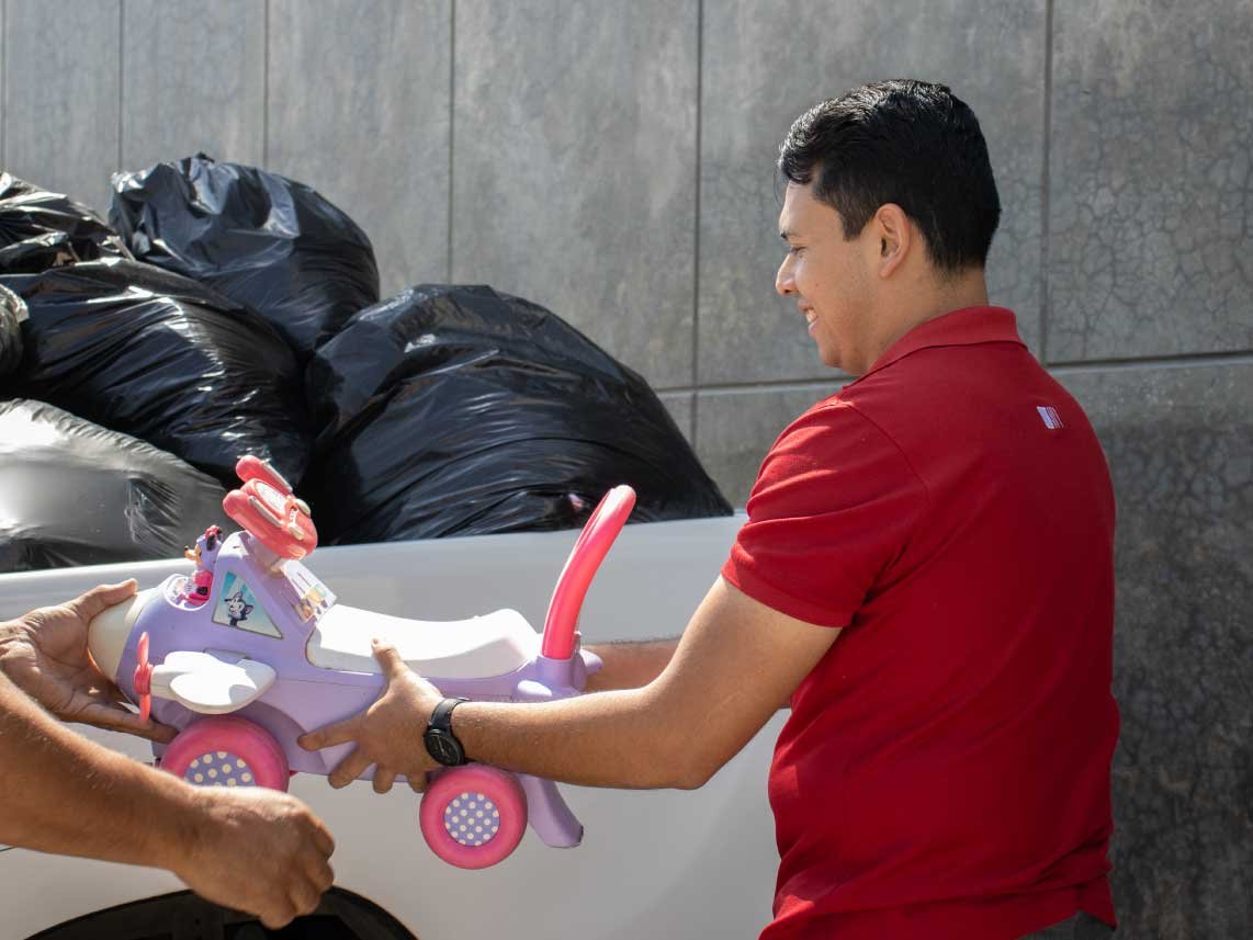 A Vectralis team member handing over a donated toy at the Vamos Guerreros bazaar