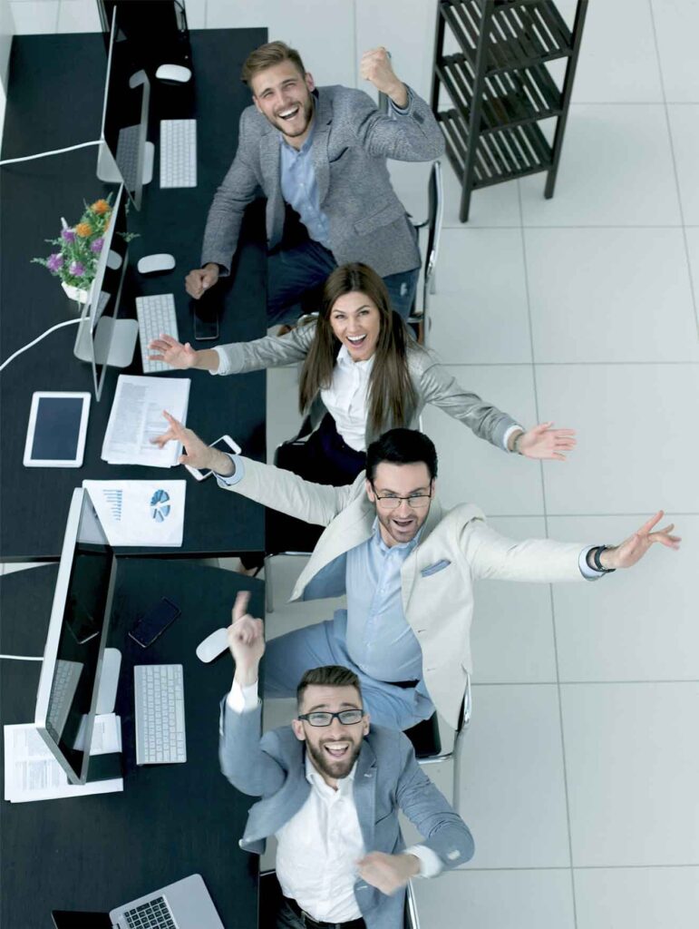 A team celebrating around a shared desk
